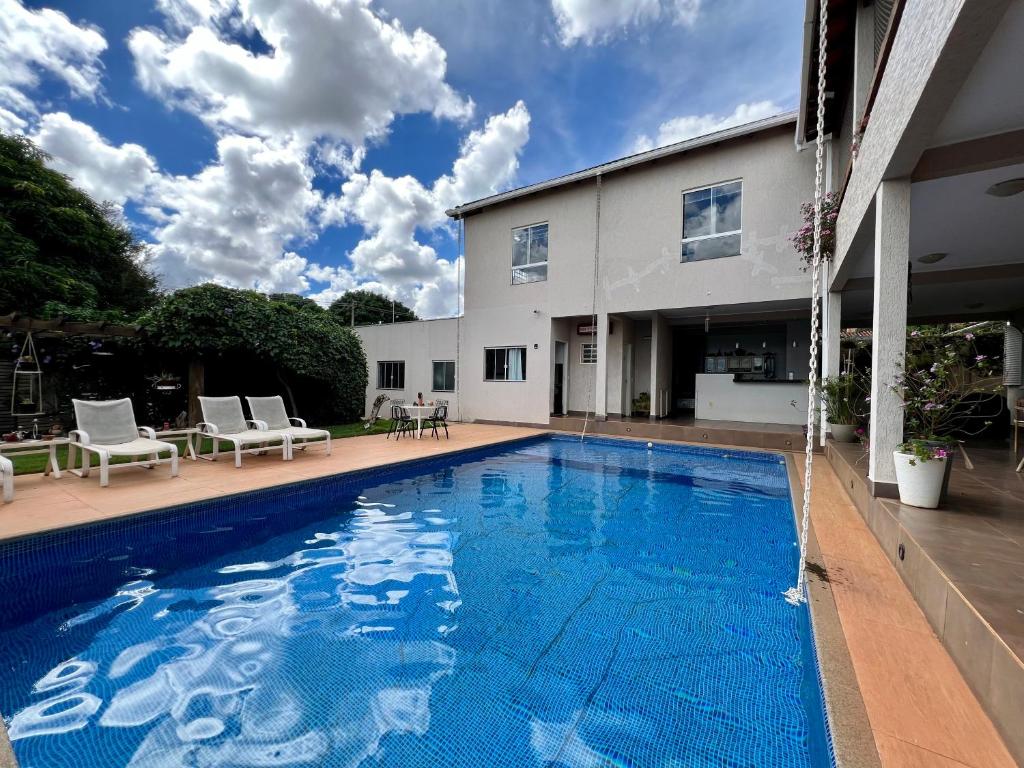 a swimming pool in front of a house at A Cozy Little House in a Beautiful Property in Brasilia