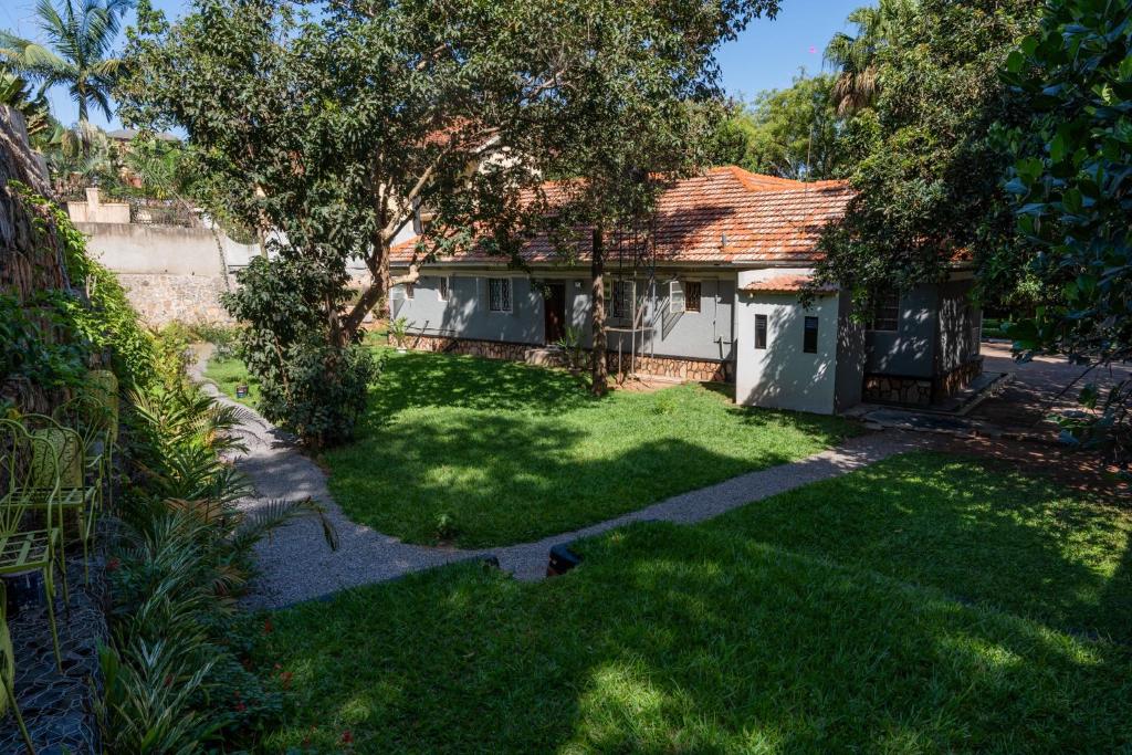 a house with a green yard with a tree at Green Square Grove - Entire House in Kampala