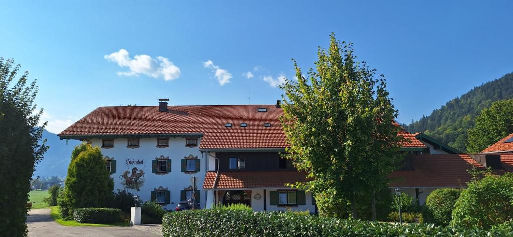 ein großes weißes Haus mit rotem Dach in der Unterkunft Karsten Gauselmanns Heißenhof Hotel garni in Inzell