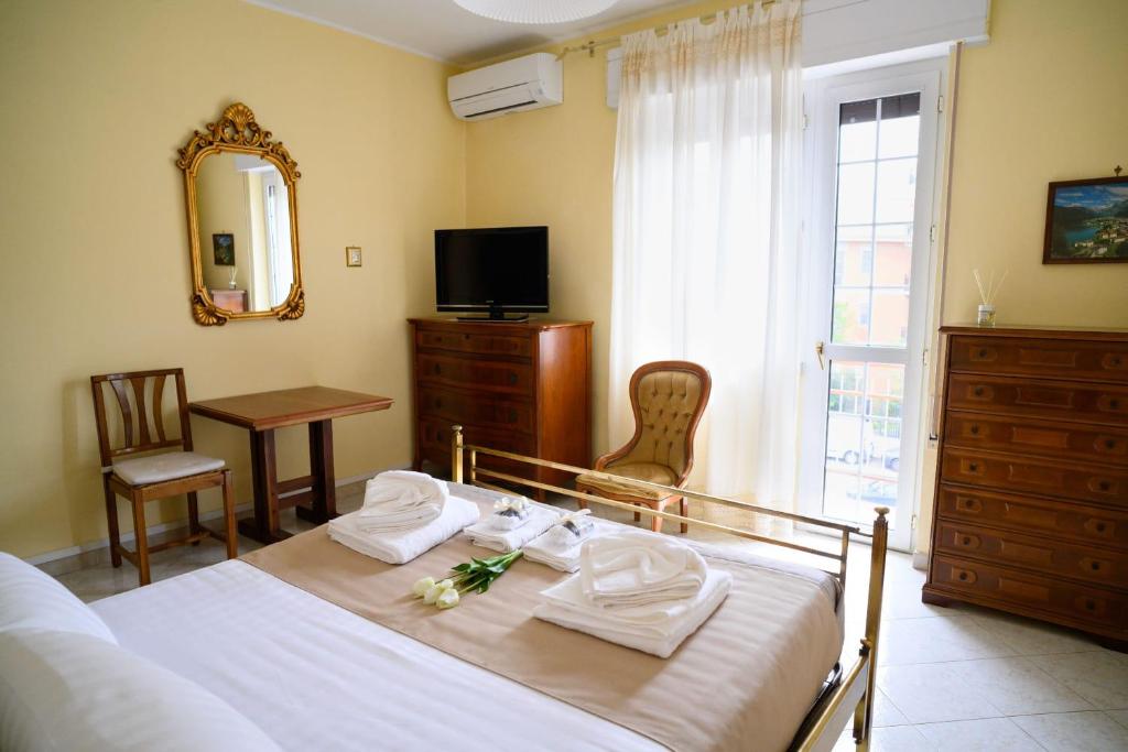 a bedroom with a bed and a table and a mirror at Relaxing House in Lido di Ostia