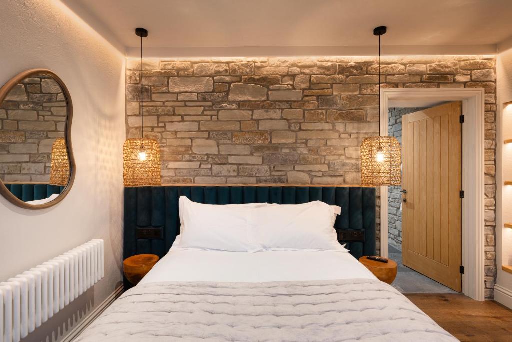 a bedroom with a bed and a brick wall at Hive Townhouse in Aberaeron