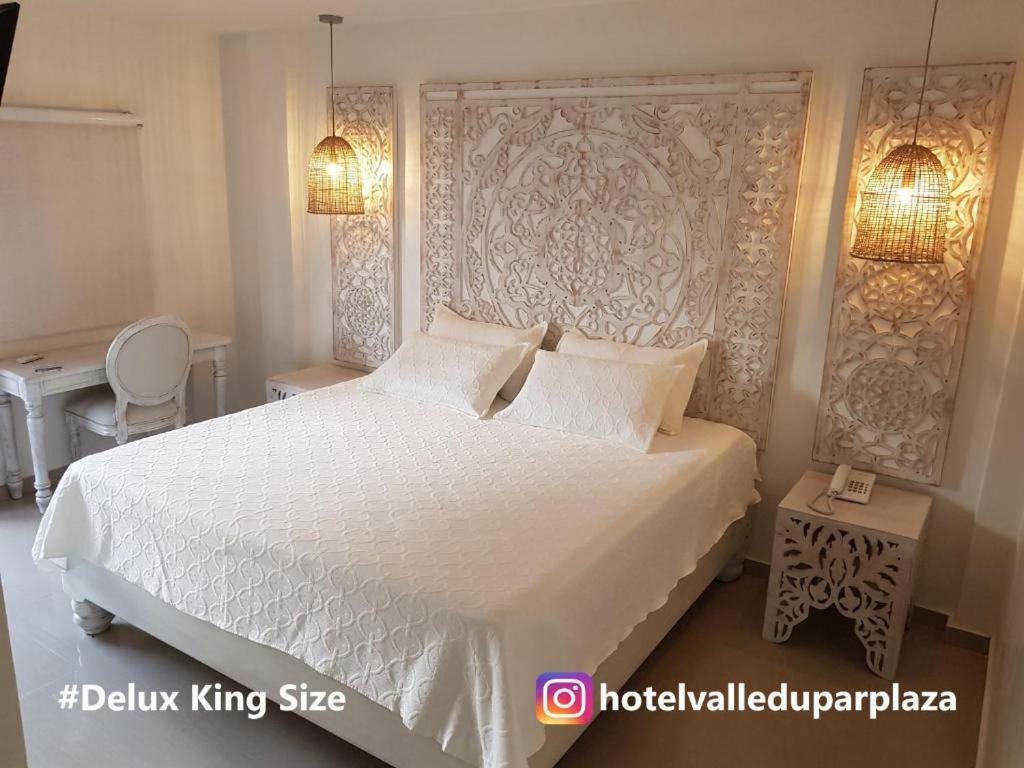 una camera con un letto bianco con due cuscini di Hotel Valledupar Plaza a Valledupar