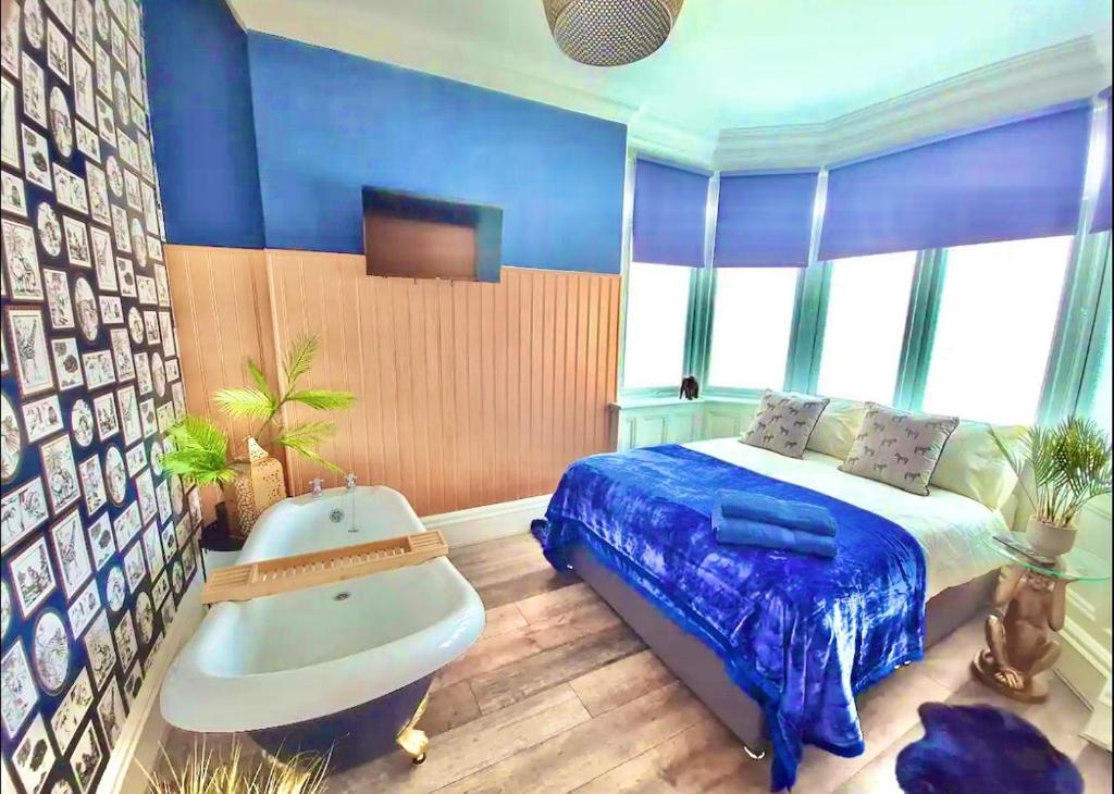 Blue Cheetah Lemur Lodge في بورنموث: غرفة نوم بسرير وحوض استحمام وحوض استحمام