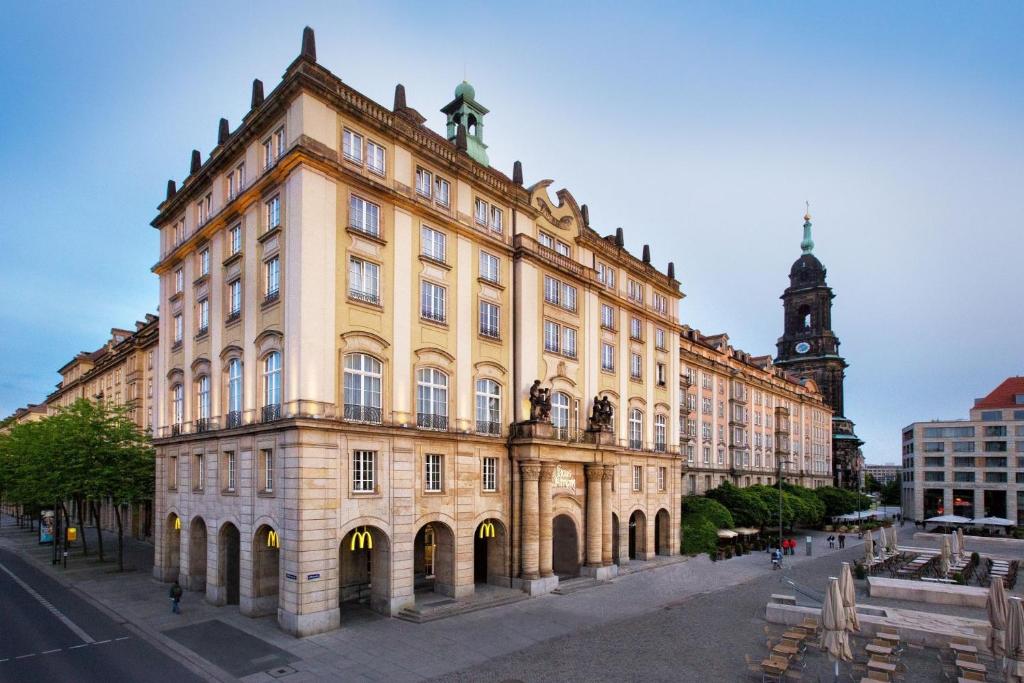 a large building with a statue on top of it at Star G Hotel Premium Dresden Altmarkt in Dresden