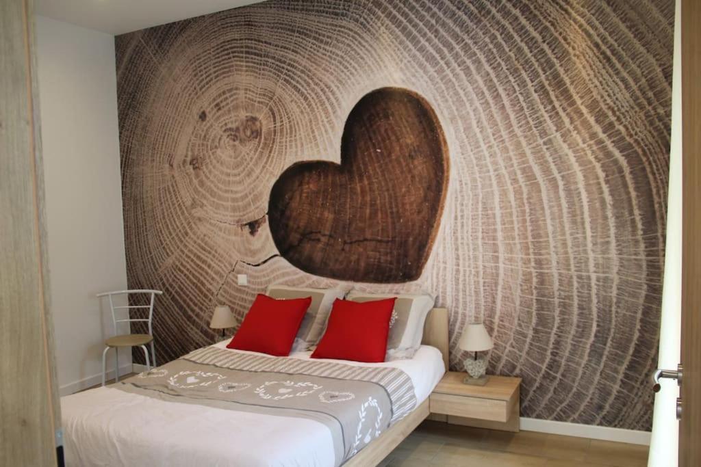 a bedroom with a bed with a heart wall at Escapade Sélest' in Sélestat