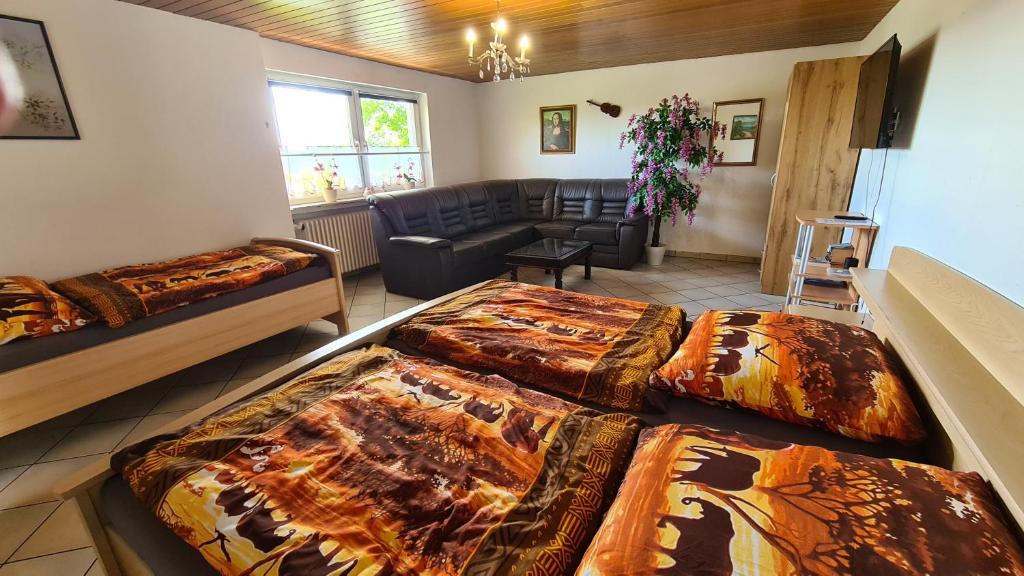 Zimmer mit 2 Betten und einem Wohnzimmer in der Unterkunft Ferienwohnung Zauberhaft in Bad Soden-Salmünster