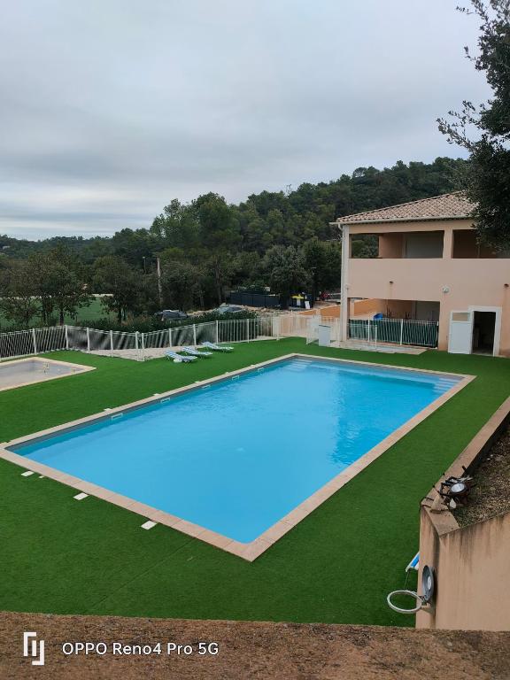 a large blue swimming pool in front of a house at Camping Soleiluna in Rocbaron