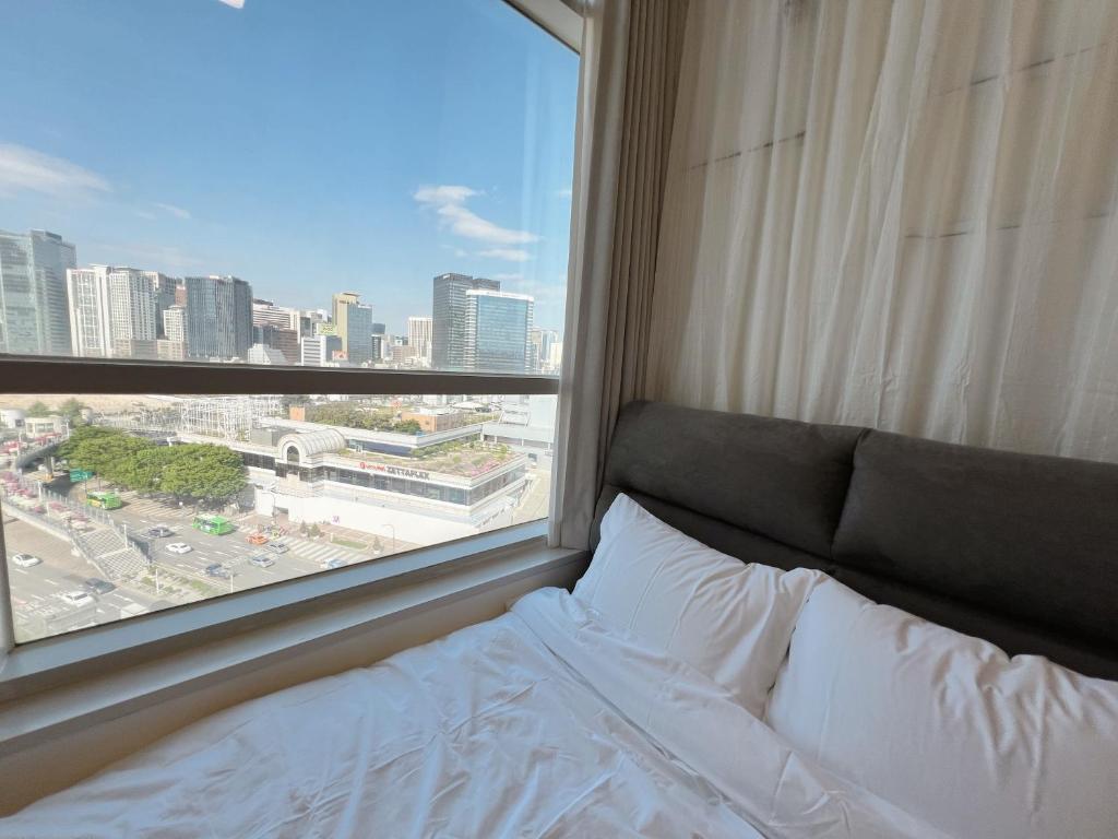 a bed in a room with a large window at Seoul downtown 3min to Seoul station in Seoul