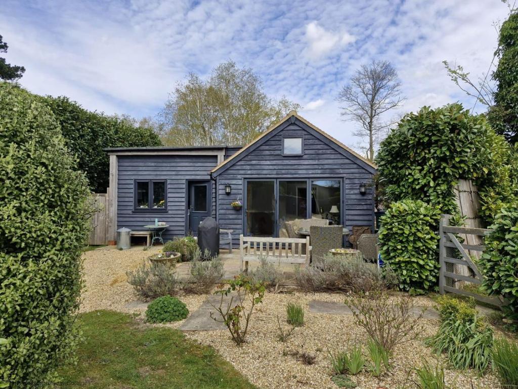 a blue house with a garden in front of it at The Shed - Pulborough in Pulborough