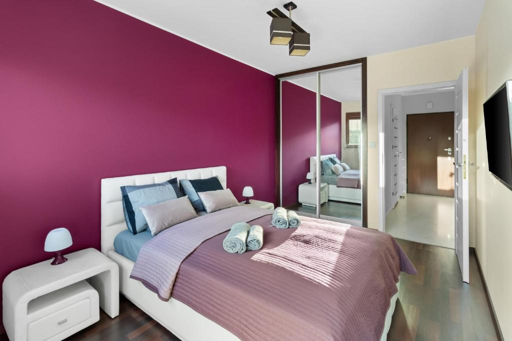 a purple bedroom with a bed and a mirror at Apartment Oxygen by Your Freedom in Warsaw