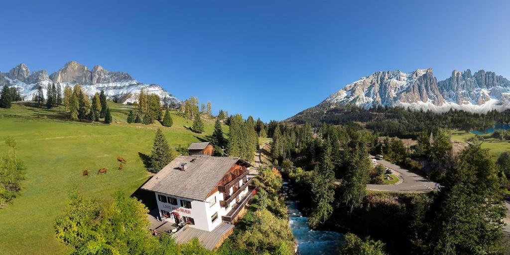 an aerial view of a house in the mountains at LAKE & RIVER Hotel in Carezza al Lago