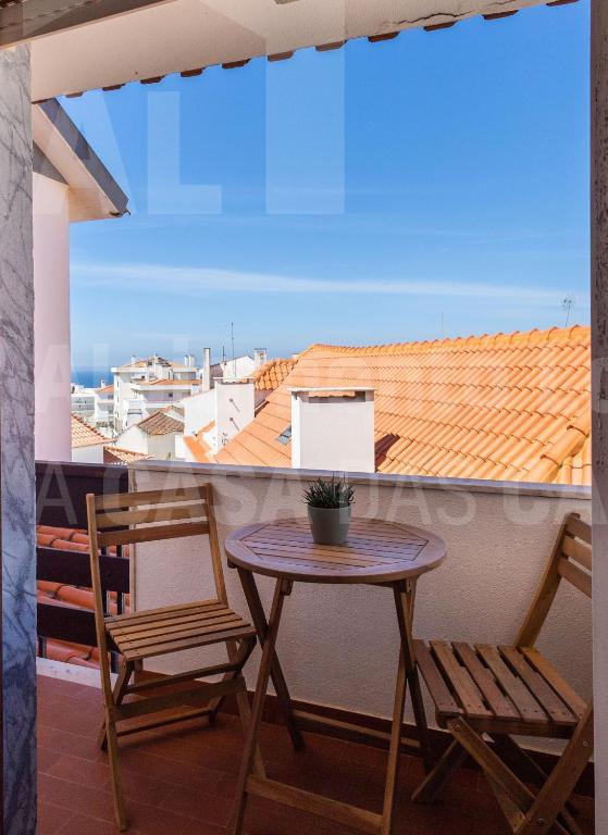 a table and two chairs on a balcony with a view at Casa do Pedro by ACasaDasCasas in Ericeira