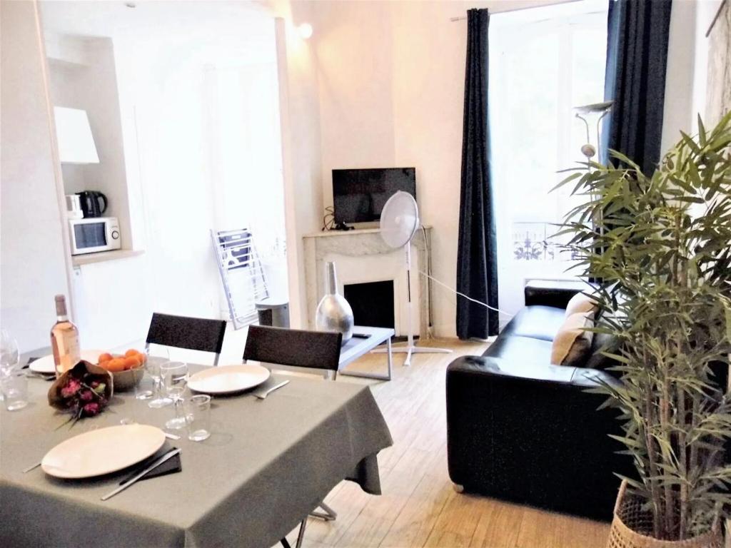 un salon avec une table et un canapé dans l'établissement Appartement confortable au cœur de Nice - Vue sur la ville, à Nice