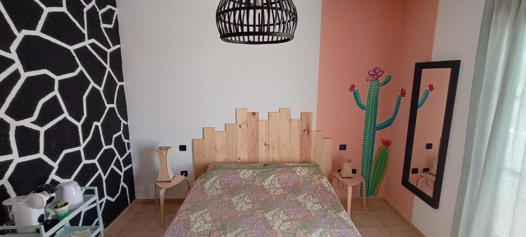 um quarto com uma cama e uma parede de cactos em Casa Luz em Yaiza