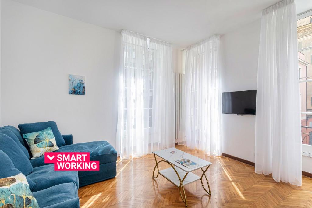 uma sala de estar com um sofá azul e uma televisão em Charming Family Apartment by Wonderful Italy em Gênova