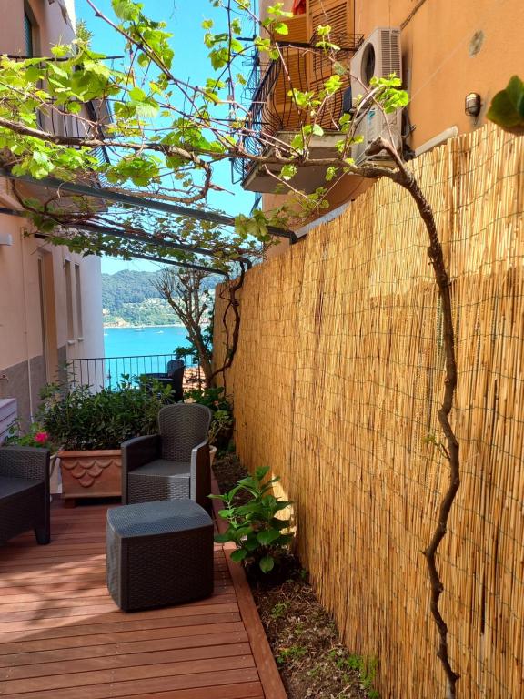 a retaining wall with a patio with chairs and a fence at Casa Vacanze Ibiscus in Portovenere