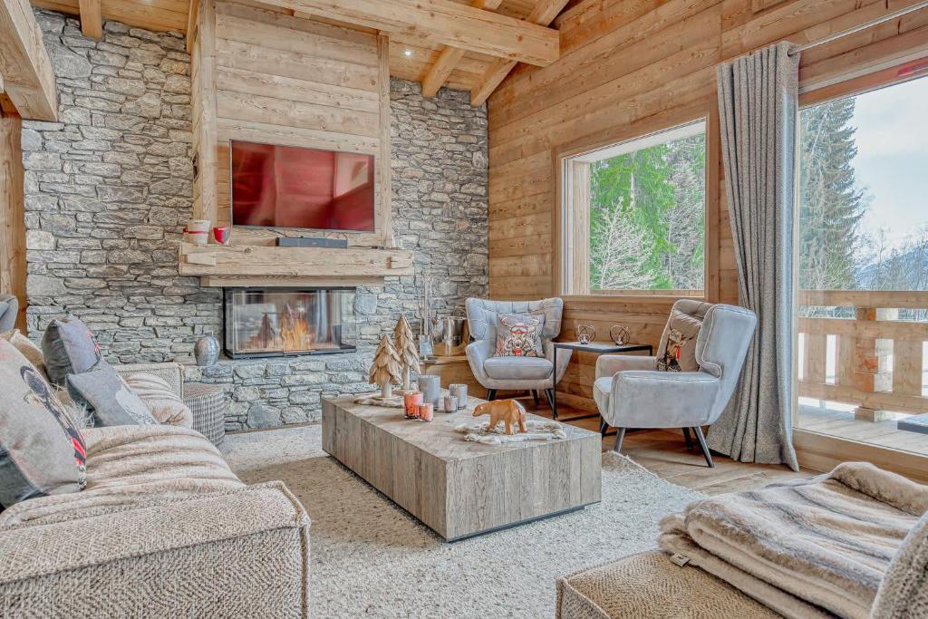 a living room with a couch and a fireplace at Chalet Indiana in Combloux