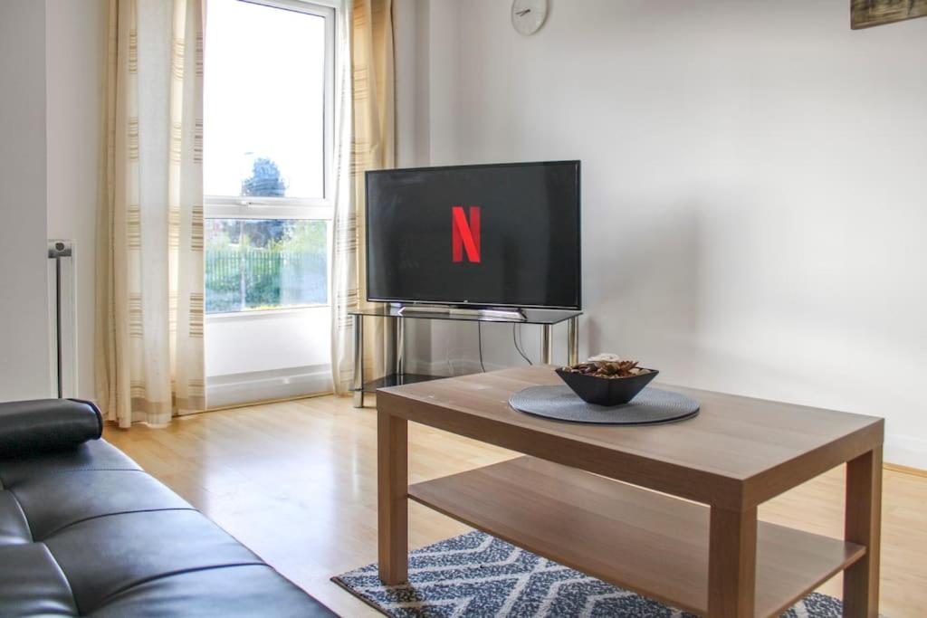 a living room with a tv and a coffee table at Modern 2-Bed in Watford Centre in Watford