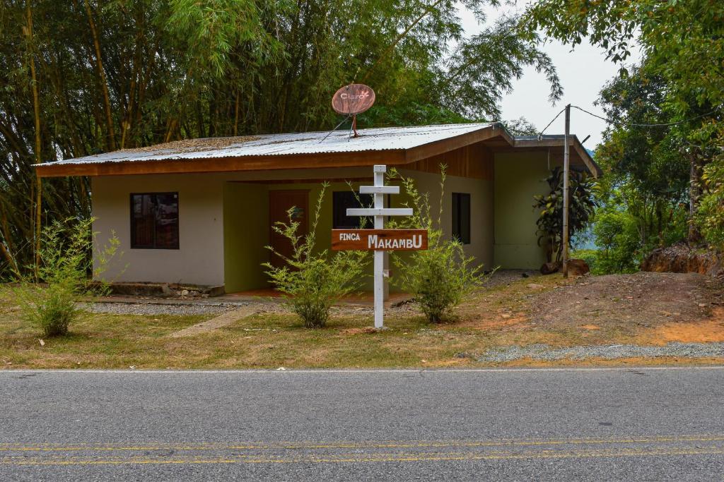 una pequeña casa con un cartel delante en Finca Makambu, en Platanillo