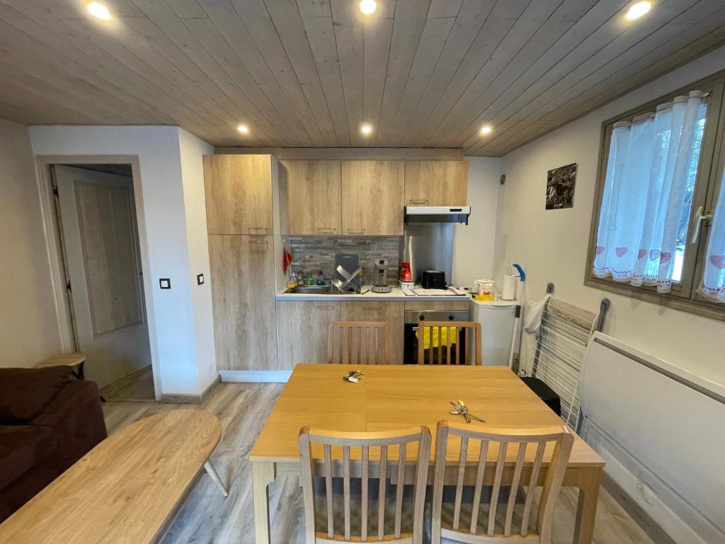 a small kitchen with a wooden table and chairs at LE PICOULET : Appartement tout confort Coeur de village( 5/7 ) in Allos