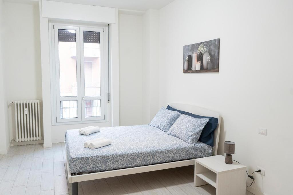 Bett in einem weißen Zimmer mit Fenster in der Unterkunft CE6 - [Corso Sempione] • Large Apartment in Mailand