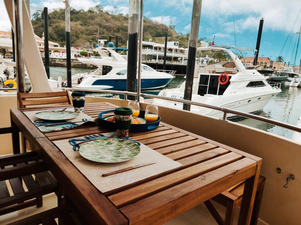 uma mesa de madeira com pratos de comida num barco em Amazing Vintage Yacht in the best area of Panama! em Cidade do Panamá