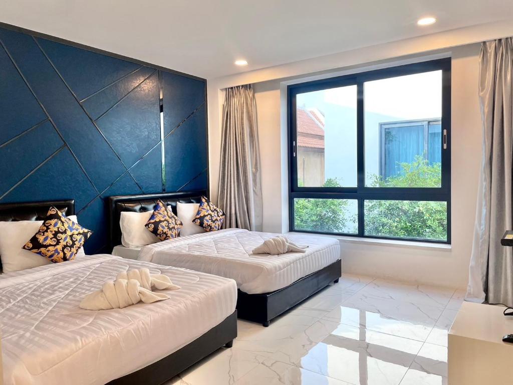 a bedroom with two beds and a large window at Pupae Pool Villa Pattaya in Pattaya South