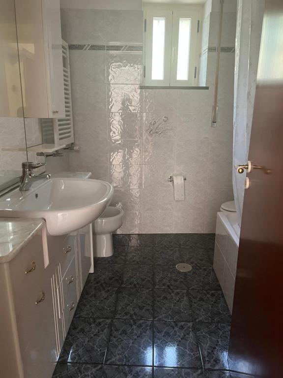 uma casa de banho branca com um lavatório e um WC em La dimora di zeus em Agerola