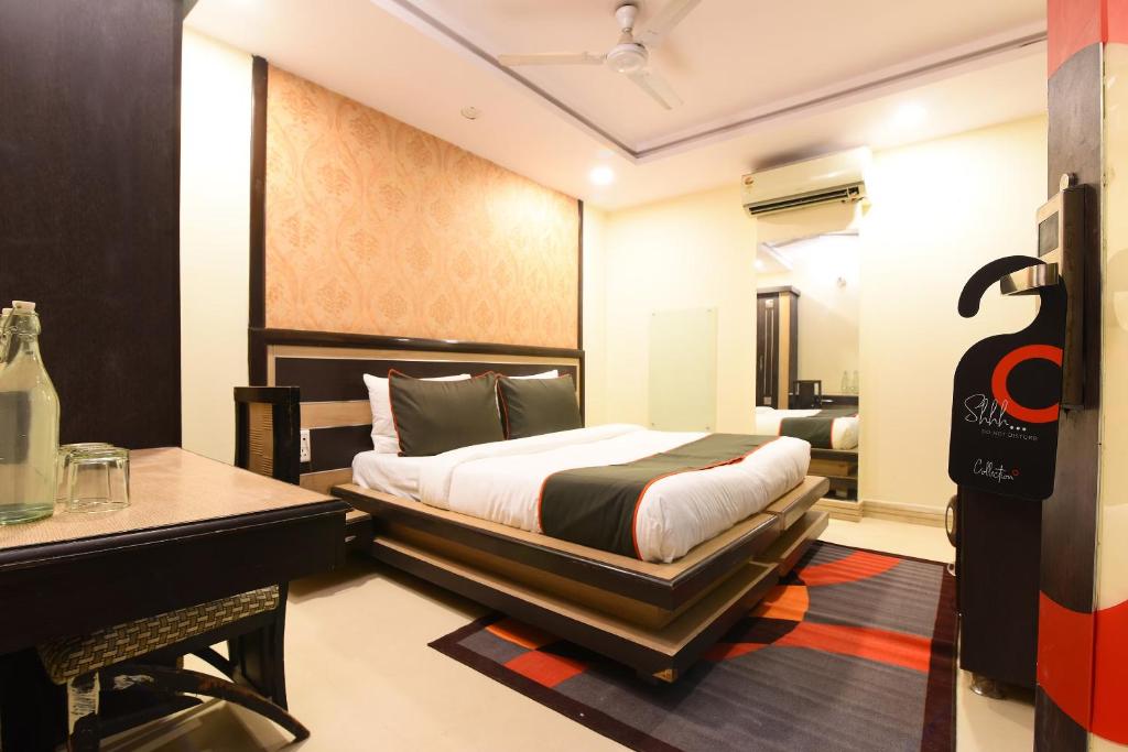 a bedroom with a bed and a desk in a room at Hotel Franklein Stay At Delhi Airport in New Delhi