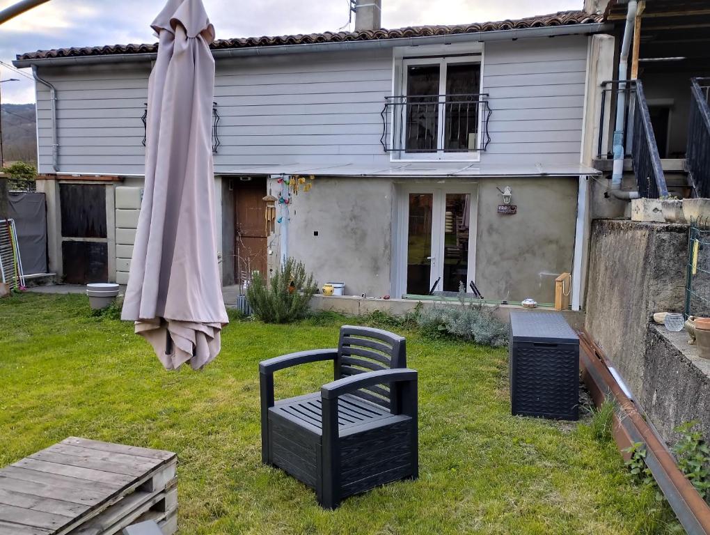 een tuin met een stoel en een paraplu bij Le petit nid in Montgaillard