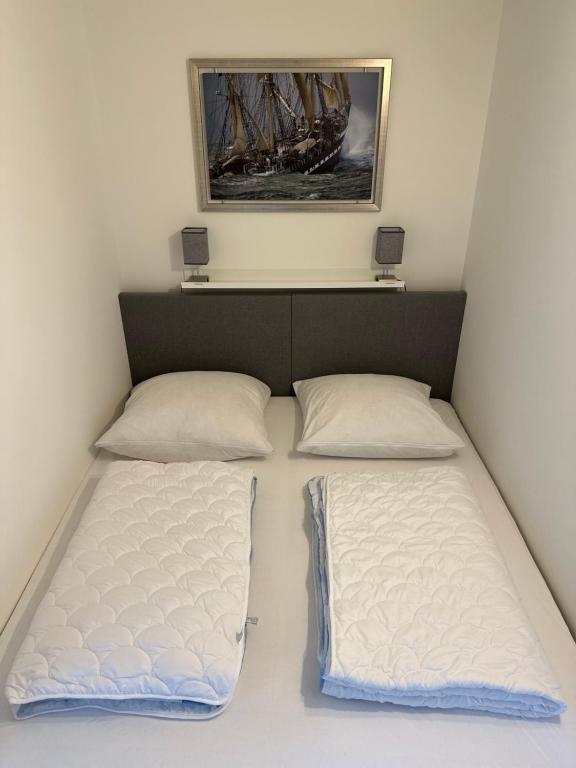 um quarto com duas camas e uma foto na parede em Fehmarn Ferienwohnung Weber Captains Corner Südstrand WHG 59-110 em Fehmarn