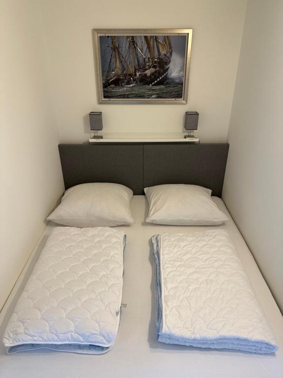 una camera da letto con due letti e un quadro sul muro di Ferienvermietung Fehmarn Captains Corner Südstrand WHG 59-110 a Fehmarn