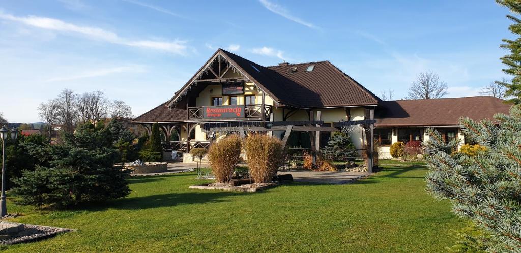 a large house with a green lawn in front of it at Tajemniczy Ogród Szczytna in Szczytna