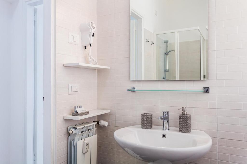 bagno bianco con lavandino e specchio di St Peter Lodge a Roma