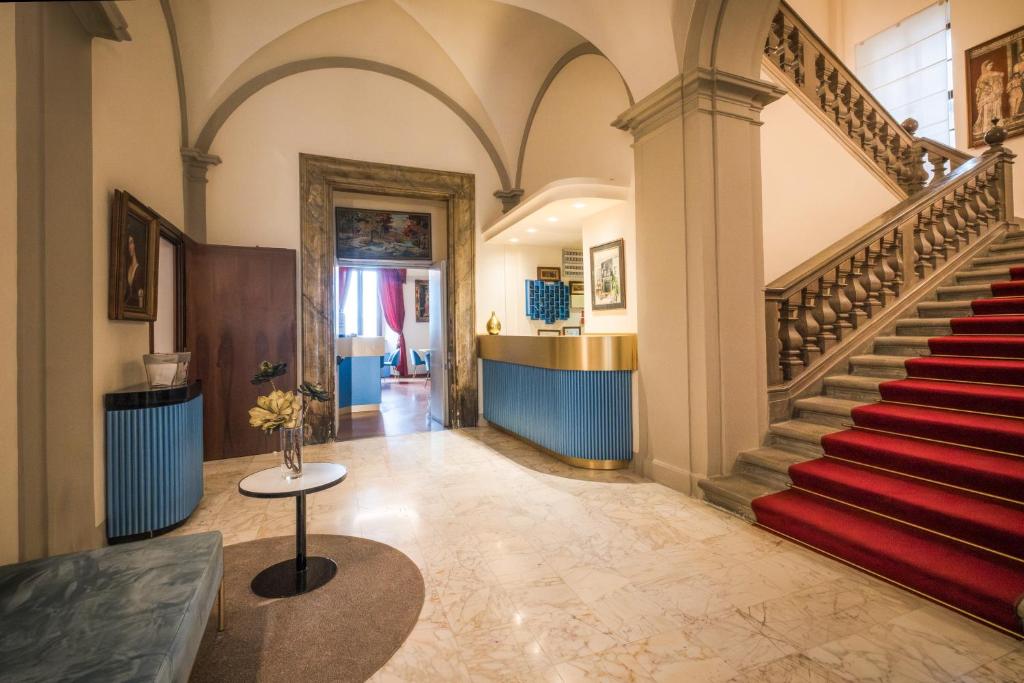 a staircase in a building with a red stair case at Bosone Palace in Gubbio