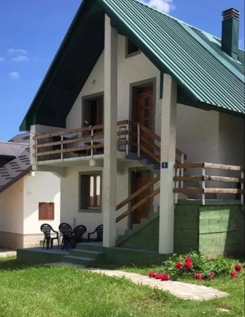 a house with a balcony and tables and chairs at Žabljak Apartman in Žabljak