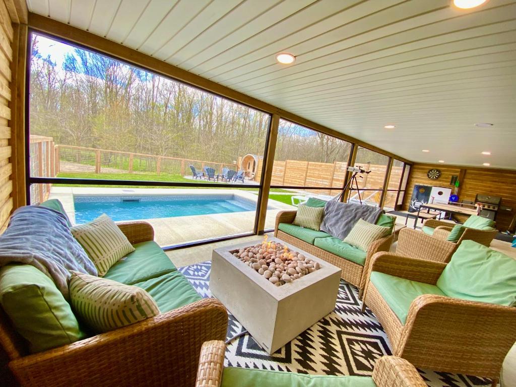 uma sala de estar com um sofá e cadeiras e uma piscina em Kings Woods Lodge Resort in Wine Country with Heated Pool, Sauna & Games em Kingsville