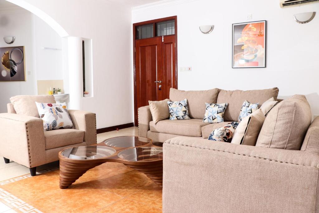 a living room with two couches and a coffee table at TANISHIA APARTMENTS in Mombasa