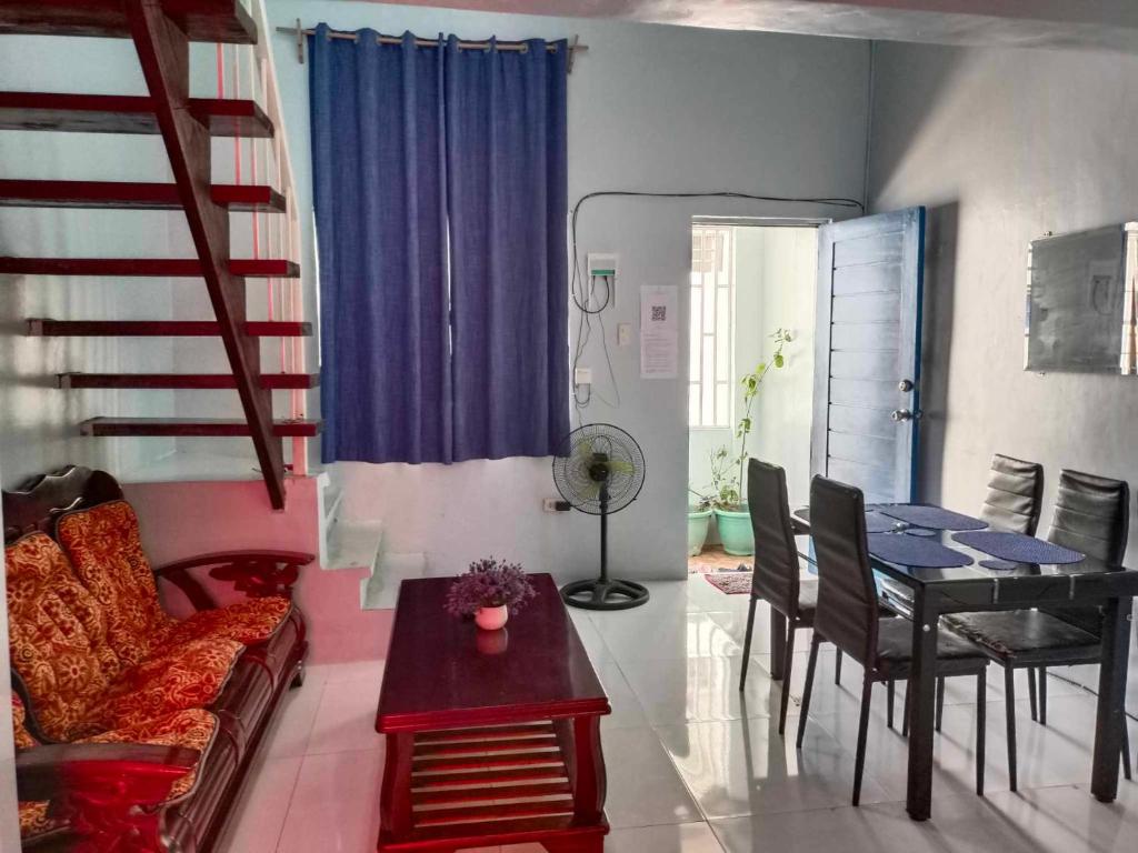 uma sala de estar com uma mesa e uma sala de jantar em Merj's Guest House in Cavite em Trece Martires