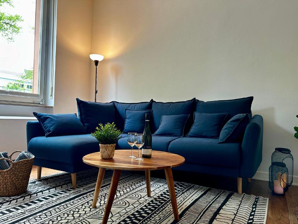 a blue couch in a living room with a table at LaBed - Ferienwohnung auf Weingut mit privater Terrasse, zentral gelegen, gratis WLAN in Rüdesheim am Rhein