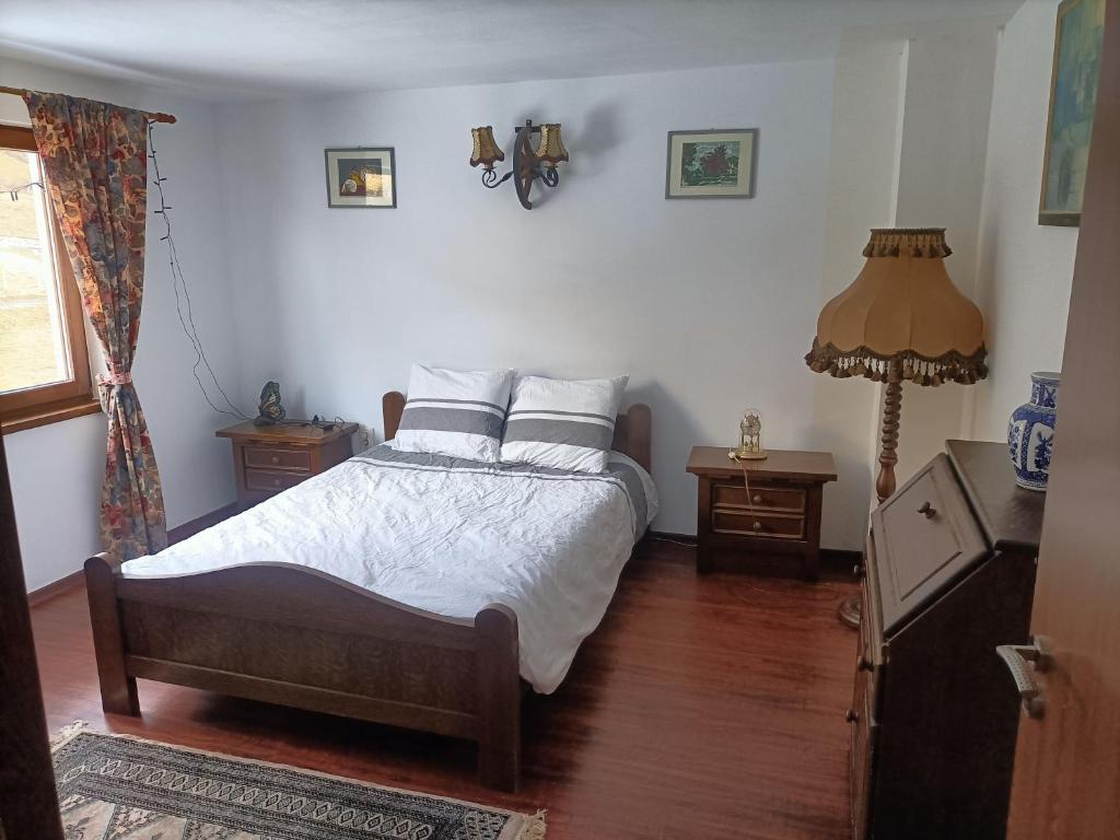 una camera da letto con un letto con lenzuola e cuscini bianchi di Cabana Țibleș a Suplai