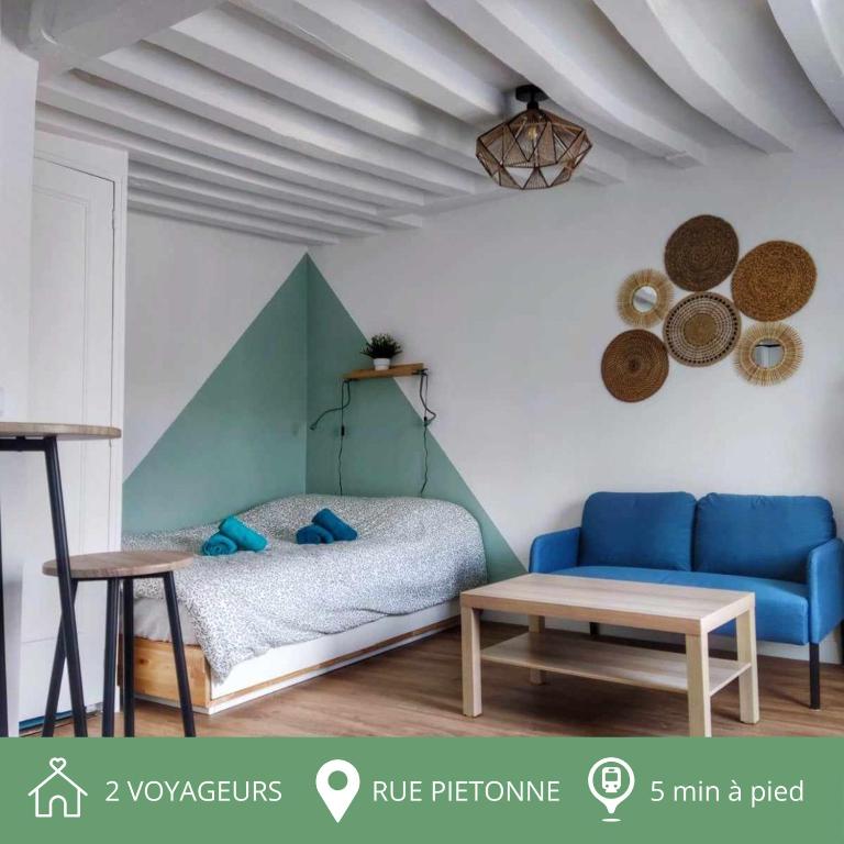 une chambre avec un canapé bleu et une table dans l'établissement Au p'tit Lagny - rue piétonne, à Lagny-sur-Marne
