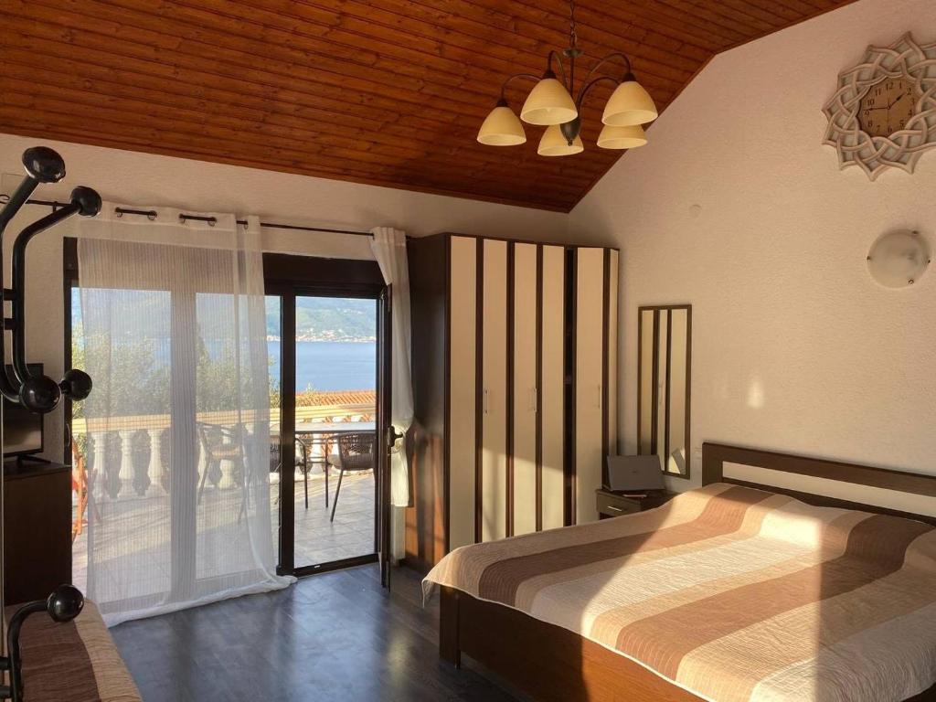 a bedroom with a large bed and a balcony at Apartments Arina in Krasici