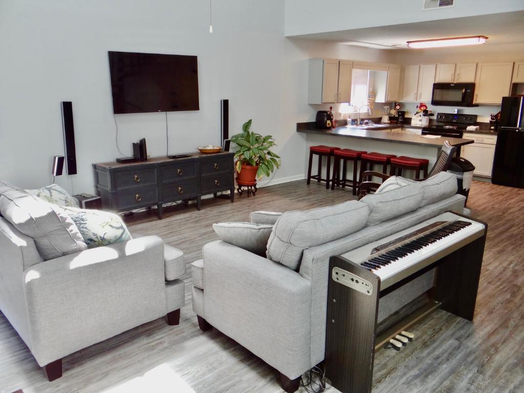 a living room with a piano and a kitchen at 35B GCR Everything Zen A Quiet Escape in Myrtle Beach