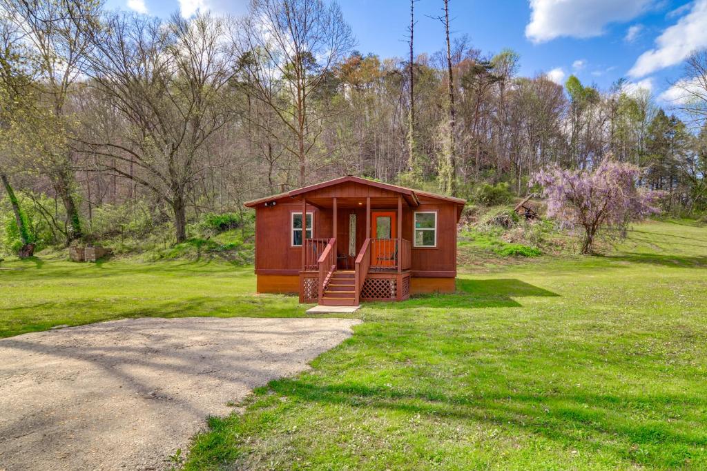 a small cabin in the middle of a grass field at Serene Beattyville Cabin 24 Mi to Red River Gorge in Beattyville