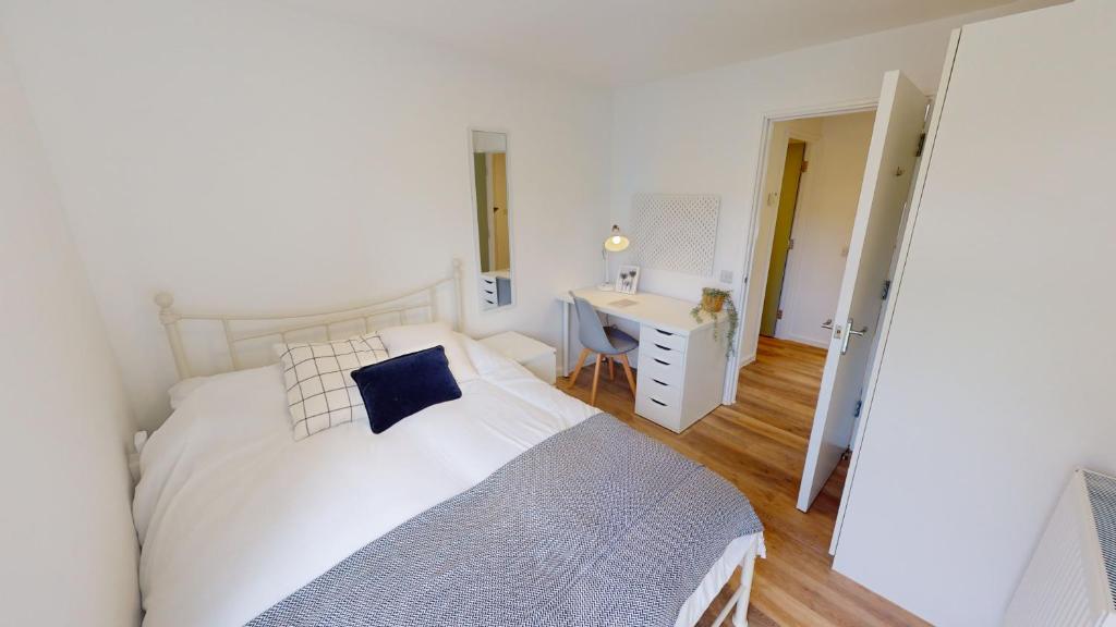 sypialnia z białym łóżkiem i biurkiem w obiekcie Charming Flat with Free Parking w mieście Exeter
