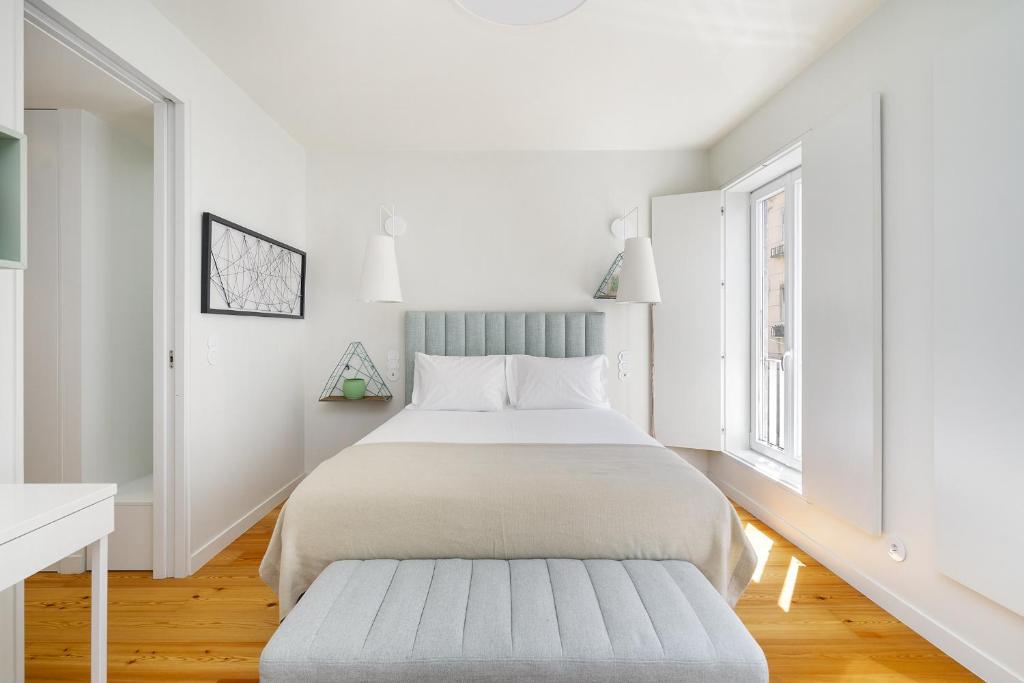a white bedroom with a bed and a window at WHome Top Floor w Luxury Design Premium Location in Lisbon