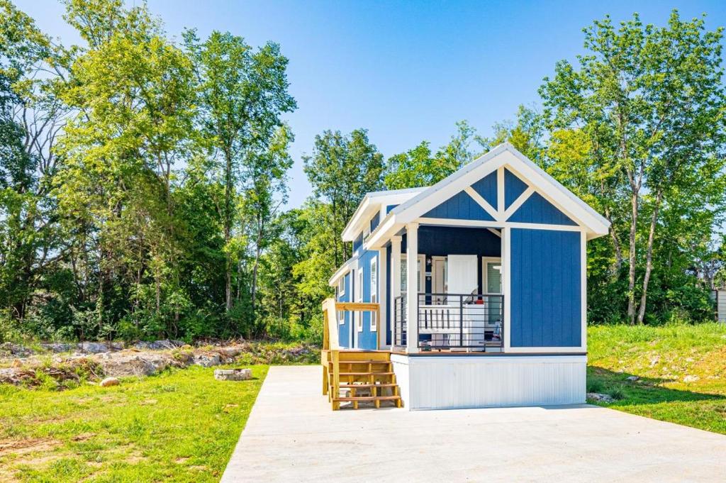 una casita azul con porche en Four Corners RV Resort, en Antioch