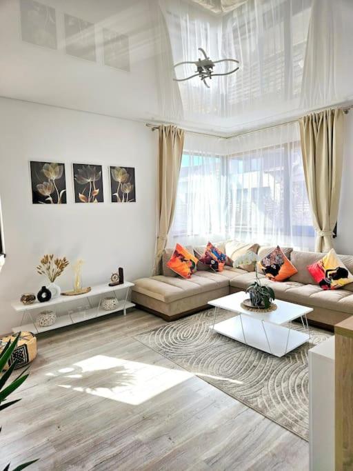 a living room with a couch and a table at Cozy SoRaDa 1 apartment in Bragadiru