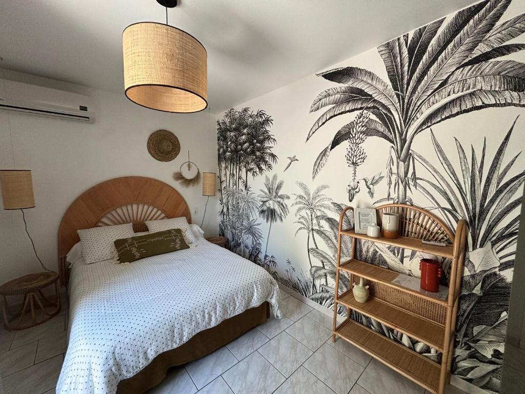 1 dormitorio con 1 cama y un mural de palmeras en un petit coin de paradis avec piscine et parking, en Villeneuve-lès-Avignon